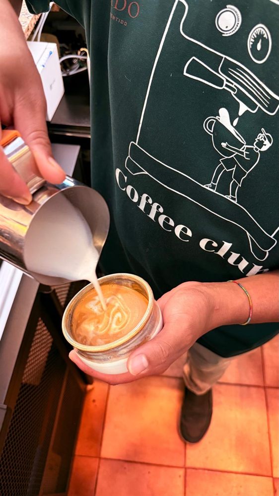 Vertiendo la leche para dibujar el arte latte en una taza.